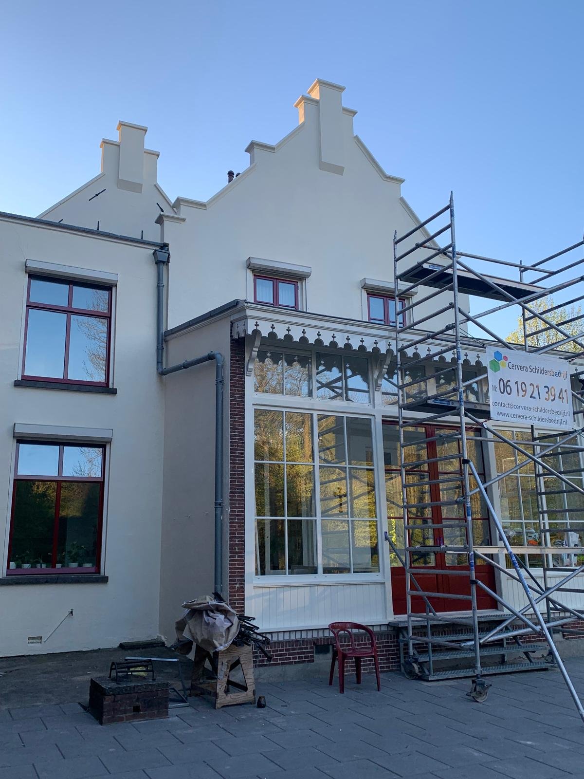 Trapgevel woning met steiger tijdens buitenschilderwerk